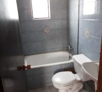 Un baño ubicado en segundo piso, tina, wc y lavamanos.