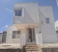 Frente, se aprecia reja de antejardín con dos entradas laterales al patio