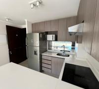 Ambiente integrado con cocina moderna de concepto abierto, ideal para optimizar espacios