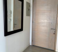 Hall de Entrada: Acogedor y funcional espacio de recepción que distribuye de manera armónica e independiente el acceso hacia la zona social y el área de descanso del departamento.