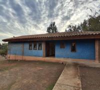 Frontis de la casa de un piso. Entrada con rampa, la puerta de entrada y ventanas de la cocina están orientadas al este