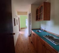 Dormitorio principal. Desde la entrada se observa una estantería, lavaplatos y cocina encimera, otorgando independencia a la suite. 