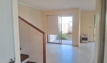 Vista desde la entrada al living. Se aprecia la escala al segundo piso. Debajo de la escala hay una bodega, y a un costado, el baño de visitas.