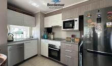 Moderna cocina integrada de gran amplitud, totalmente equipada con encimera, horno empotrado y campana de alta eficiencia