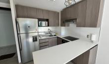 Cocina funcional y equipada con acabados contemporáneos e integración fluida al living
