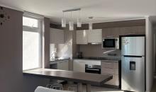 Moderna cocina integrada de concepto abierto, sumamente luminosa gracias a su ventana exterior. Se entrega completamente equipada con encimera eléctrica, horno empotrado, microondas y lavavajillas. Un espacio funcional y de excelente diseño.