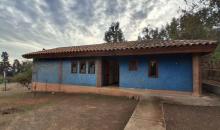 Frontis de la casa de un piso. Entrada con rampa, la puerta de entrada y ventanas de la cocina están orientadas al este