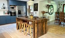 Cocina abierta con isla central, muebles azules e integración al comedor.
