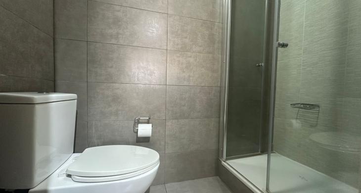 Baño principal con diseño funcional: Lavamanos independiente del área de sanitarios. Zona húmeda equipada con shower door de cristal templado, grifería moderna y revestimientos en porcelanato de alta calidad.