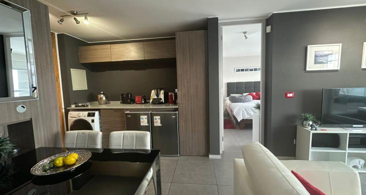 Comedor con diseño de concepto abierto, conectado a cocina con cubiertas de cuarzo