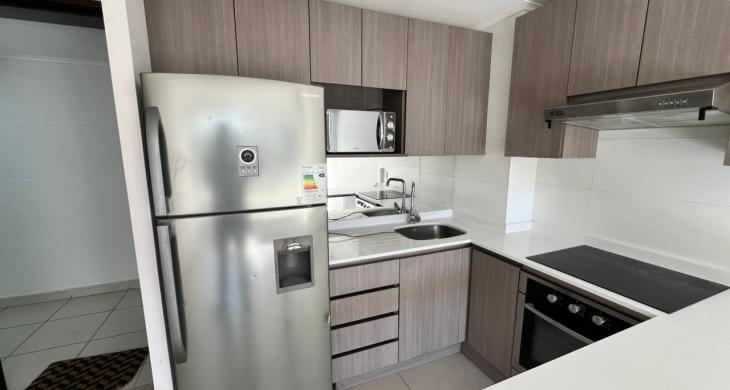 Ambiente integrado con cocina moderna de concepto abierto, ideal para optimizar espacios.