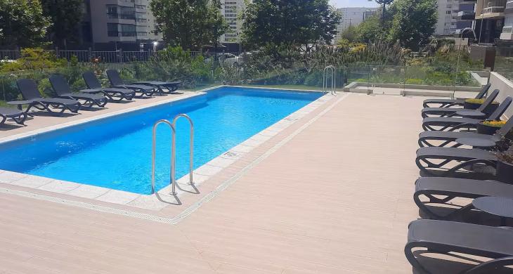 Piscina y tumbonas al aire libre