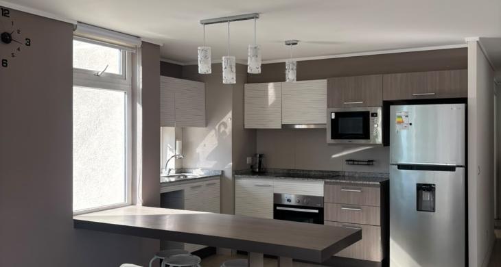 Moderna cocina integrada de concepto abierto, sumamente luminosa gracias a su ventana exterior. Se entrega completamente equipada con encimera eléctrica, horno empotrado, microondas y lavavajillas. Un espacio funcional y de excelente diseño.