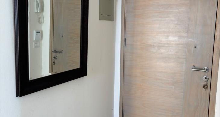 Hall de Entrada: Acogedor y funcional espacio de recepción que distribuye de manera armónica e independiente el acceso hacia la zona social y el área de descanso del departamento.