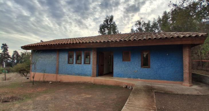 Frontis de la casa de un piso. Entrada con rampa, la puerta de entrada y ventanas de la cocina están orientadas al este