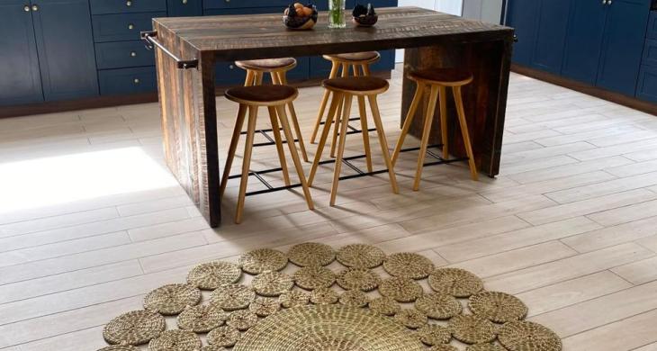 Cocina con isla central, cubierta de madera, campana y abundante luz natural.