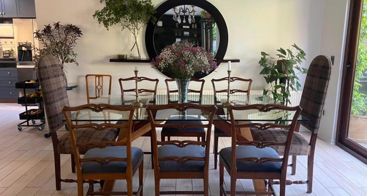 Comedor familiar con mesa de vidrio, vista al jardín y acceso directo a la cocina.